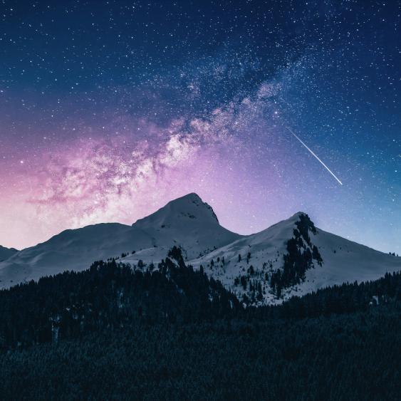 Image of mountains at night withcolors in the sky